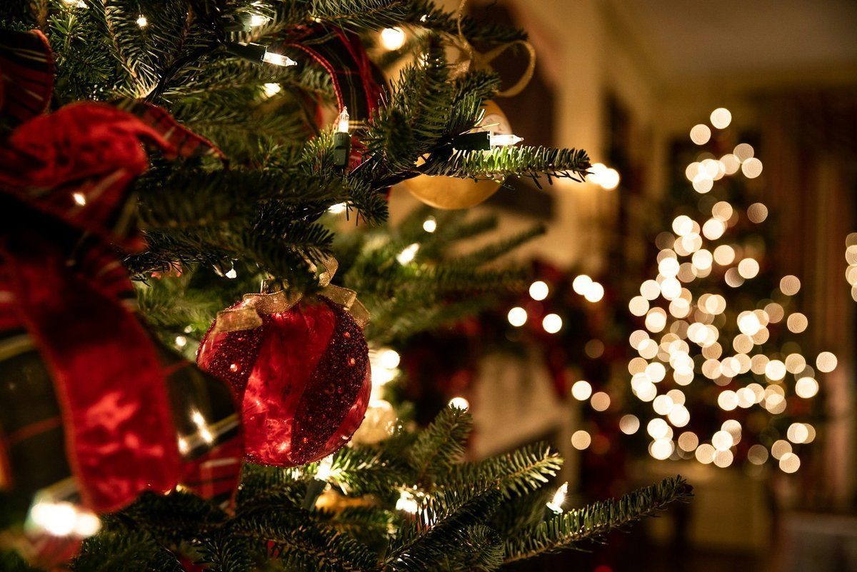 Dekorierter Weihnachtsbaum mit warmen weißen Lichtern und roten Ornamenten