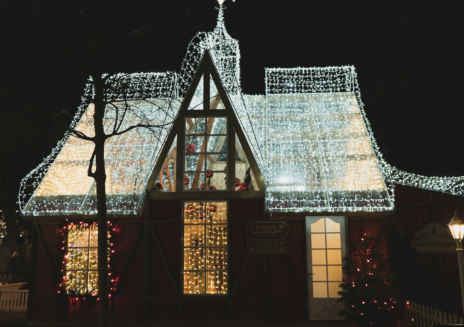 Warm white icicle lights hanging from a snow-covered house roof